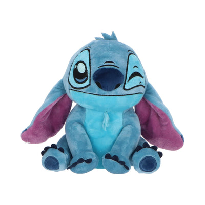 Tirelire peluche Stitch clin d’œil 20 cm posée sur une surface blanche